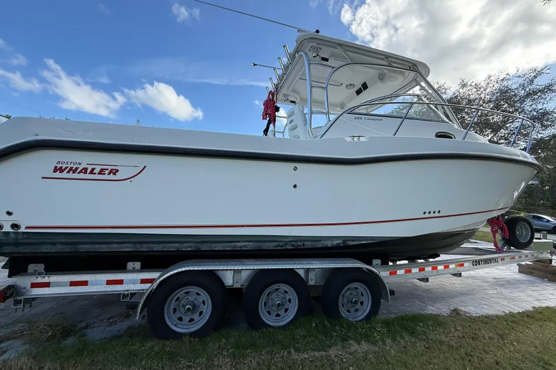  Yacht Photos Pics 2011 Boston Whaler 285 Conquest boat on trailer under blue sky.