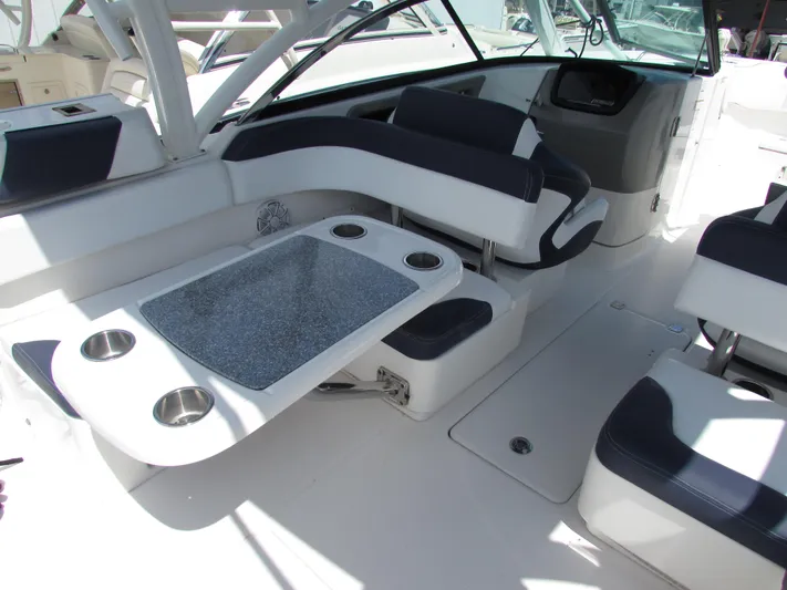 317-147 Ray Brokerage Yacht Photos Pics 2017 Robalo 317 boat interior with seating and table, featuring cup holders.