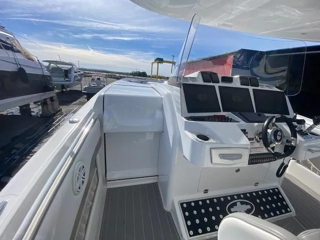 Cigarette 42 Yacht Photos Pics 2017 Cigarette 42 Huntress boat cockpit with modern controls and steering wheel, docked under clear skies.