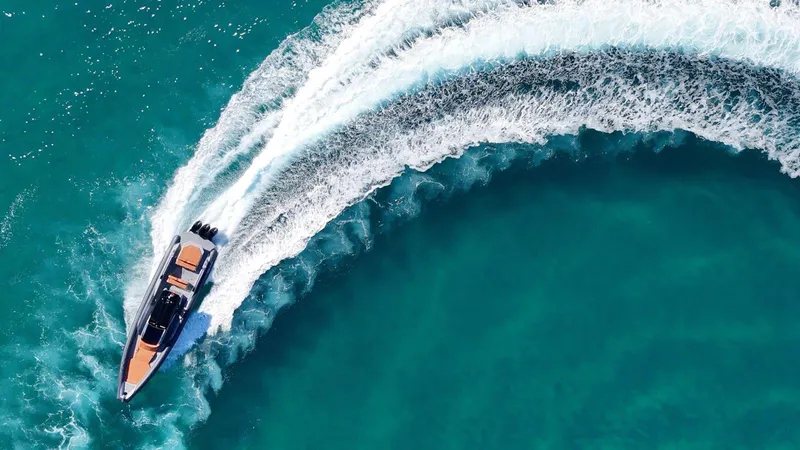  Yacht Photos Pics Aerial view of DNA 46 speedboat making a sharp turn in turquoise water.