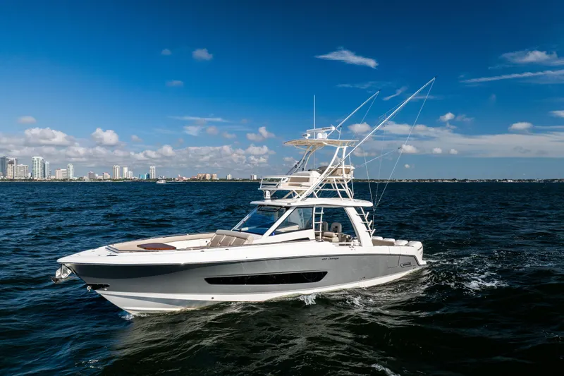 Smoke Show Yacht Photos Pics 2021 Boston Whaler 420 Outrage cruising on open water with city skyline backdrop.