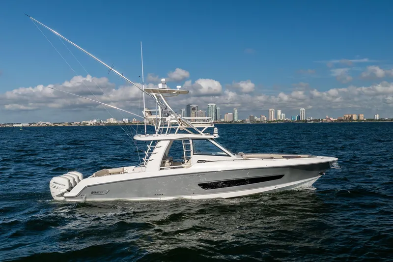Smoke Show Yacht Photos Pics 2021 Boston Whaler 420 Outrage boat cruising on open water with city skyline backdrop.