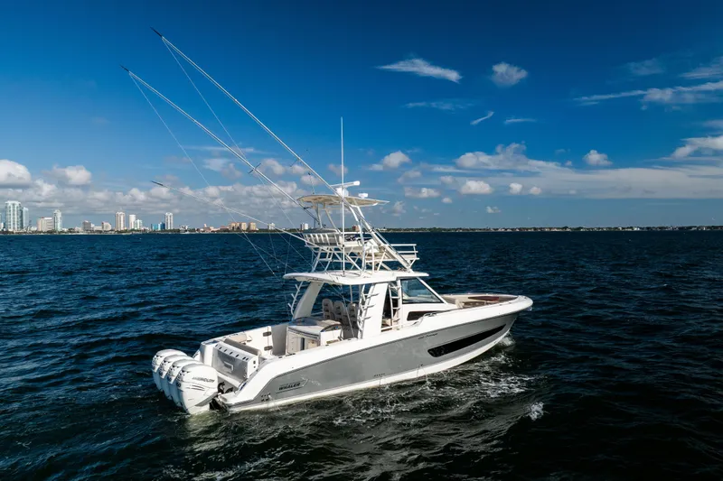 Smoke Show Yacht Photos Pics 2021 Boston Whaler 420 Outrage cruising on open water with city skyline in background.