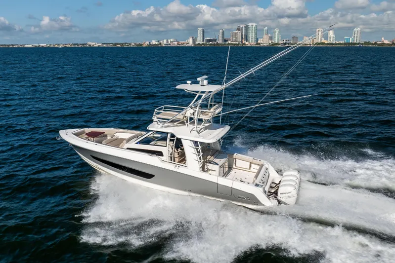Smoke Show Yacht Photos Pics 2021 Boston Whaler 420 Outrage cruising on ocean with city skyline in background.