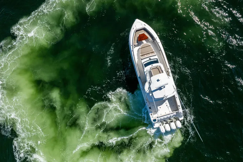 Smoke Show Yacht Photos Pics Aerial view of 2021 Boston Whaler 420 Outrage cruising through green ocean waters.