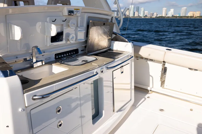 Smoke Show Yacht Photos Pics 2021 Boston Whaler 420 Outrage boat kitchen area with ocean and city skyline view.