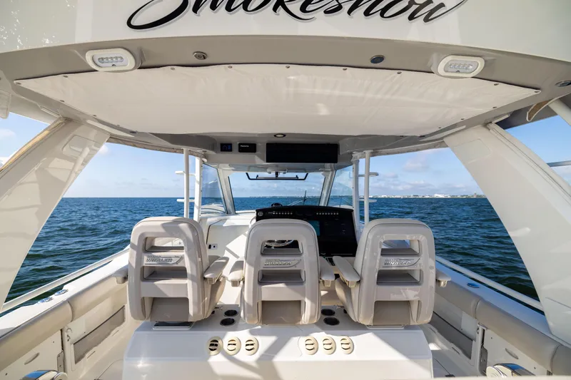 Smoke Show Yacht Photos Pics 2021 Boston Whaler 420 Outrage helm with ocean view, featuring modern seating and controls.