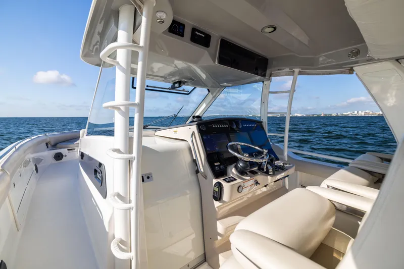 Smoke Show Yacht Photos Pics 2021 Boston Whaler 420 Outrage helm with ocean view, featuring modern controls and seating.