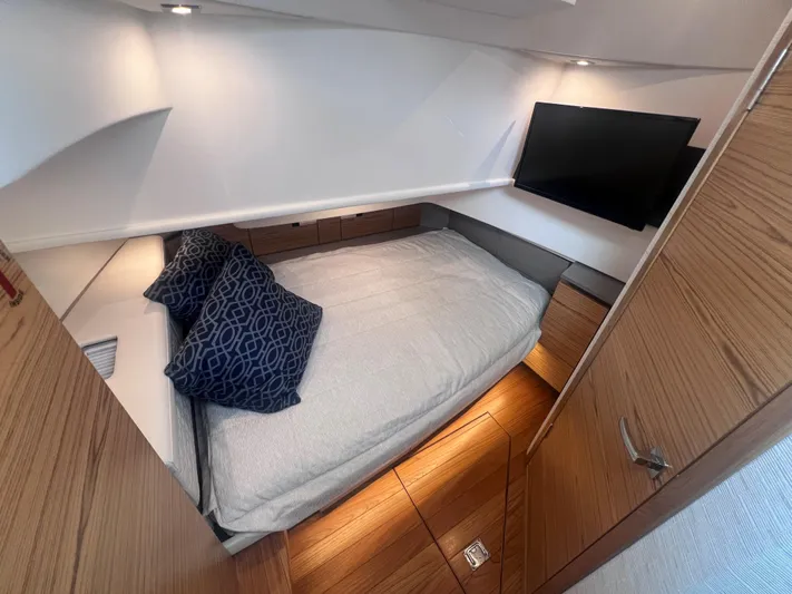  Yacht Photos Pics 2023 Tiara Yachts 38 LS cabin interior with bed, TV, and wooden accents.