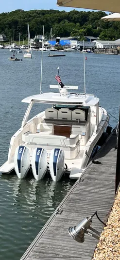  Yacht Photos Pics 2023 Tiara Yachts 38 LS docked, featuring triple outboard engines, in a scenic marina setting.