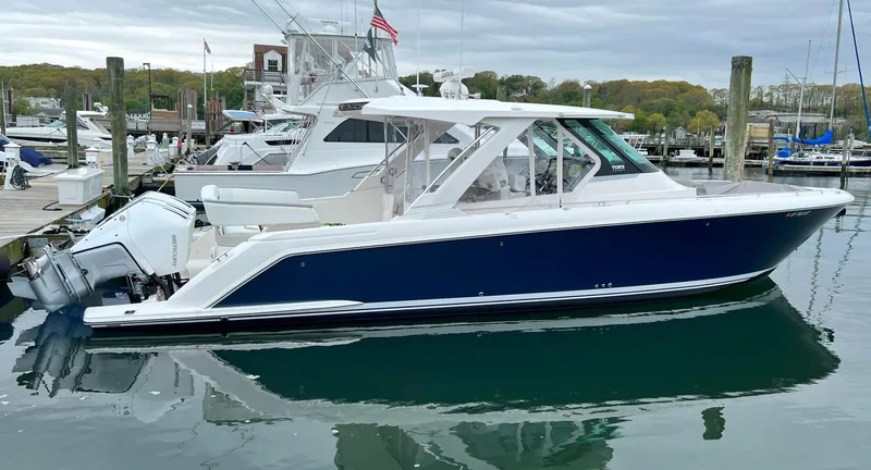  Yacht Photos Pics 2023 Tiara Yachts 38 LS boat docked in a marina, featuring sleek design and powerful engines.