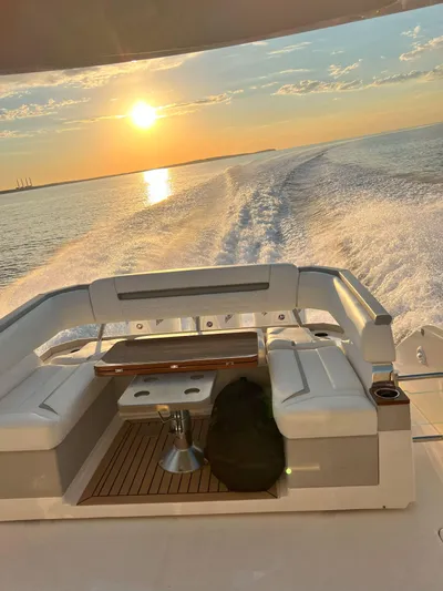  Yacht Photos Pics 2023 Tiara Yachts 38 LS cruising at sunset, leaving a wake on the water.