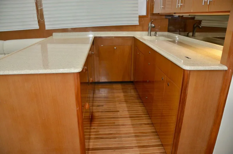 Tomaso 5 Yacht Photos Pics Luxurious kitchen interior of 2004 Viking 52 Convertible yacht with wooden cabinetry and countertops.