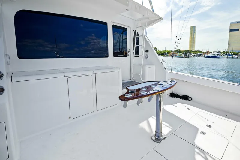 Tomaso 5 Yacht Photos Pics 2004 Viking 52 Convertible yacht deck with fishing rod holders, overlooking marina.