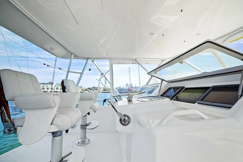 Tomaso 5 Yacht Photos Pics Interior view of 2004 Viking 52 Convertible yacht cockpit with white seating and controls.