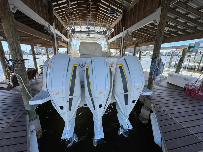  Yacht Photos Pics 2020 Intrepid 407 Cuddy boat with triple outboard engines docked in a covered marina.