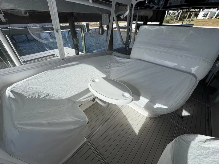  Yacht Photos Pics 2020 Intrepid 407 Cuddy interior with white seating and table, docked by the water.