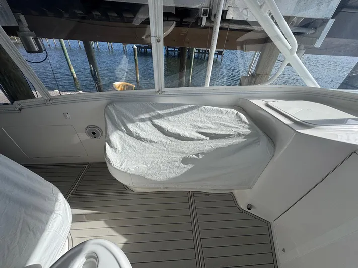  Yacht Photos Pics 2020 Intrepid 407 Cuddy boat interior with covered seating and wooden deck, dockside view.