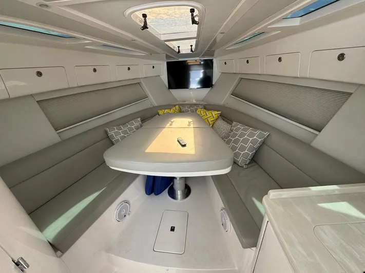  Yacht Photos Pics 2020 Intrepid 407 Cuddy interior with seating, table, and cushions in a modern design.