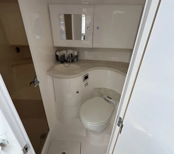  Yacht Photos Pics 2020 Intrepid 407 Cuddy boat bathroom with toilet, sink, and mirror.