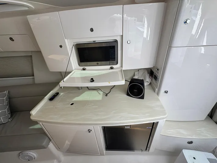  Yacht Photos Pics 2020 Intrepid 407 Cuddy interior with microwave, fridge, and sleek cabinetry.