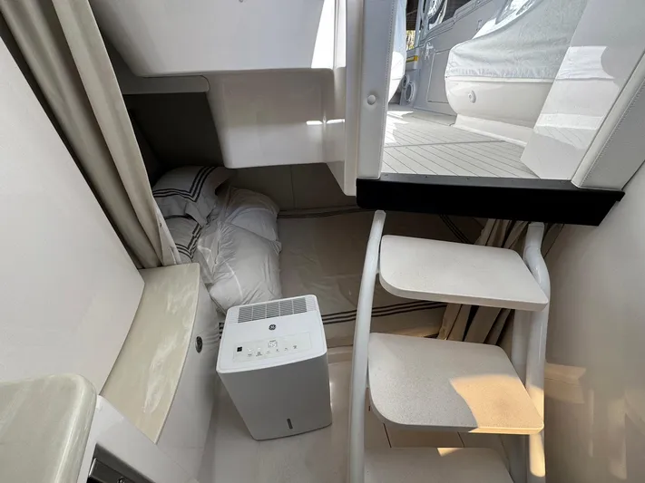  Yacht Photos Pics 2020 Intrepid 407 Cuddy cabin interior with stairs, bedding, and air purifier.