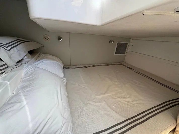  Yacht Photos Pics 2020 Intrepid 407 Cuddy cabin interior with bed and striped bedding.