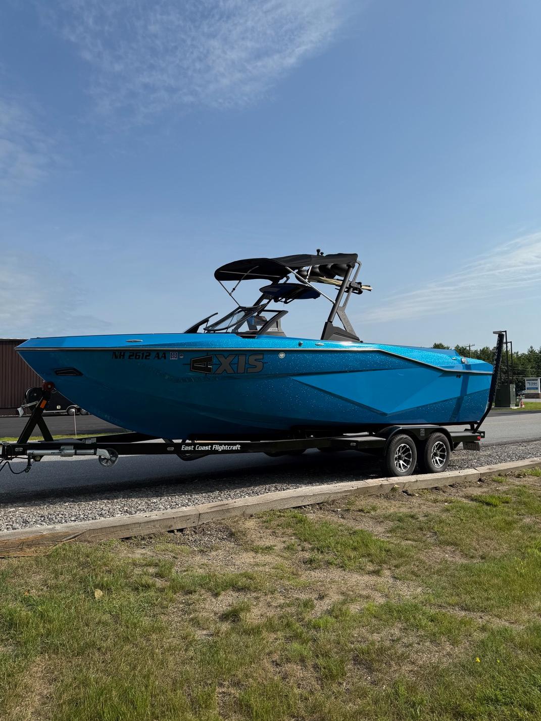 2022 Axis T250 boat in blue on a trailer, parked outdoors.
