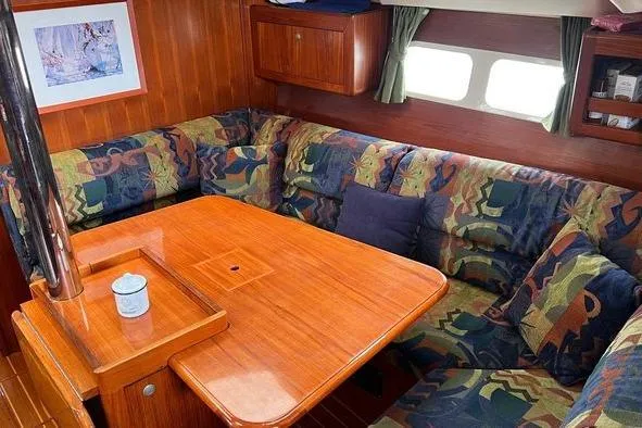  Yacht Photos Pics Cozy interior of 1999 Hunter 410 sailboat with colorful seating and wooden table.