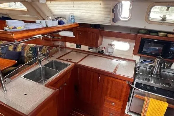  Yacht Photos Pics Interior of a 1999 Hunter 410 yacht kitchen with wooden cabinetry and modern appliances.