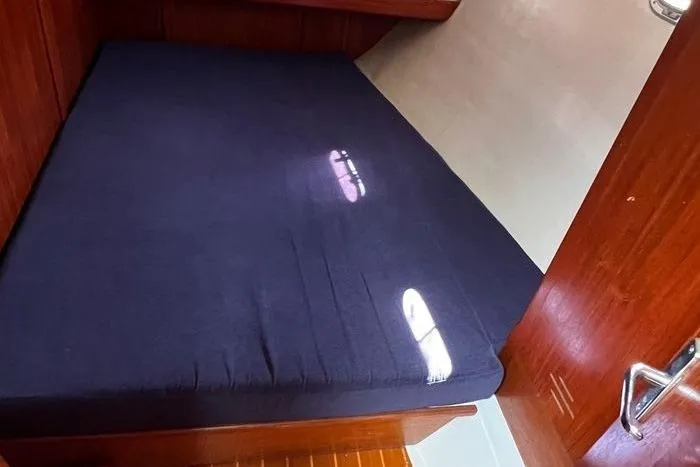  Yacht Photos Pics 1999 Hunter 410 cabin interior with dark blue mattress and wooden finish.