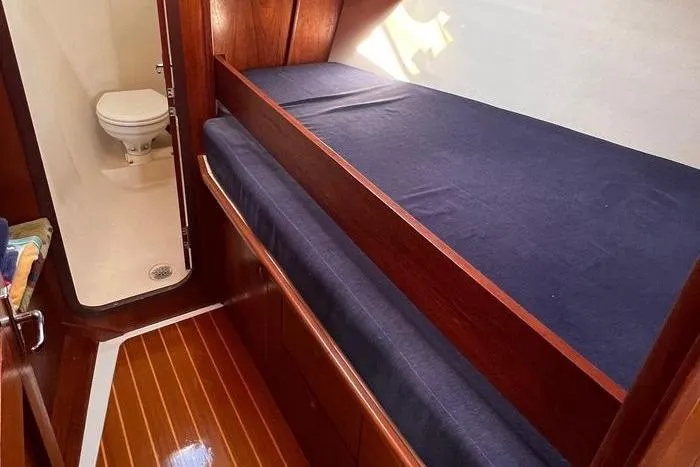 Yacht Photos Pics 1999 Hunter 410 yacht interior with wooden flooring, bed, and compact bathroom.
