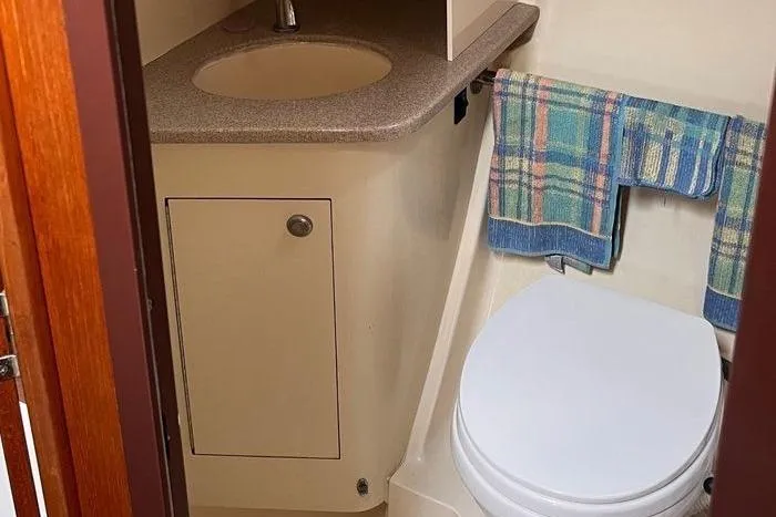  Yacht Photos Pics Compact bathroom in 1999 Hunter 410 sailboat with sink, toilet, and towel rack.