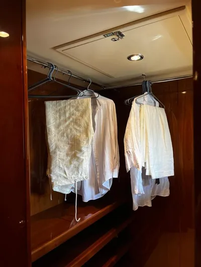 My Sons Yacht Photos Pics Wooden closet with white shirts hanging, inside a Falcon 86 yacht, 2008 model.