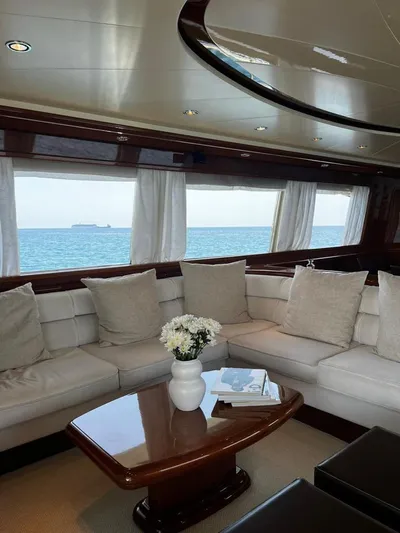 My Sons Yacht Photos Pics Luxurious Falcon 86 yacht interior with ocean view, featuring elegant seating and a wooden table.