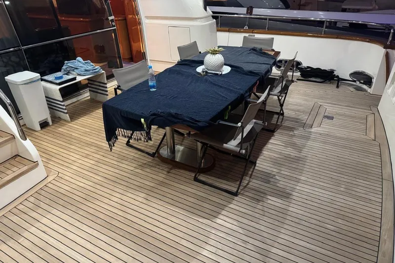 My Sons Yacht Photos Pics Luxurious Falcon 86 yacht deck with dining table, chairs, and elegant wooden flooring, 2008 model.