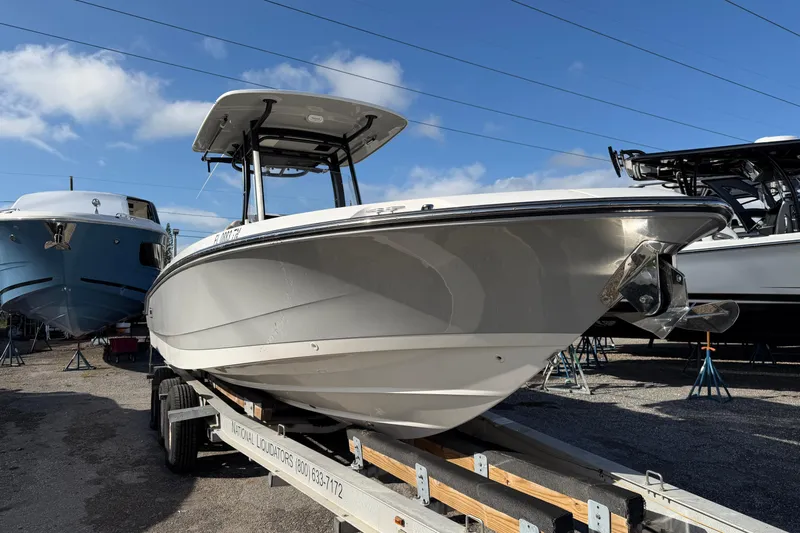  Yacht Photos Pics 2023 Boston Whaler 280 Dauntless boat on trailer, parked outdoors under blue sky.