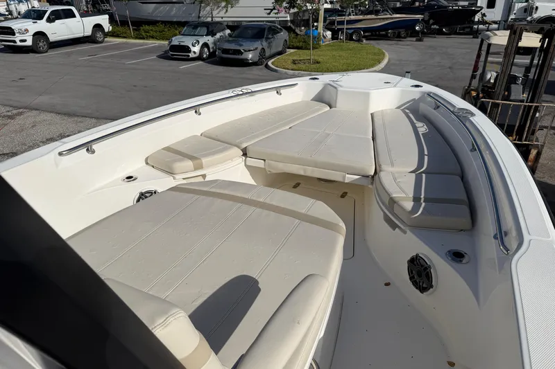  Yacht Photos Pics 2023 Boston Whaler 280 Dauntless boat interior with cushioned seating in a parking lot.