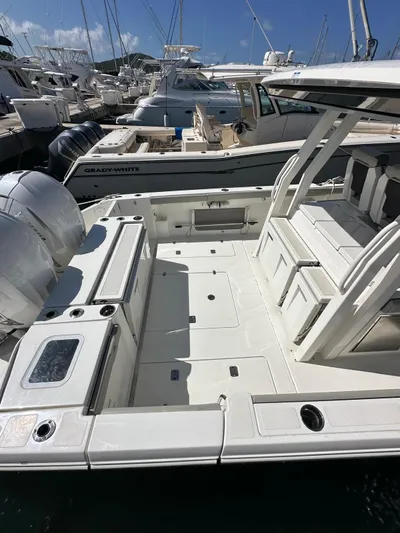  Yacht Photos Pics 2023 Pursuit S 358 Sport boat docked, featuring spacious deck and dual engines.