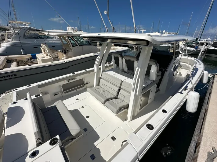 Yacht Photos Pics 2023 Pursuit S 358 Sport boat docked at marina, featuring spacious seating and sleek design.