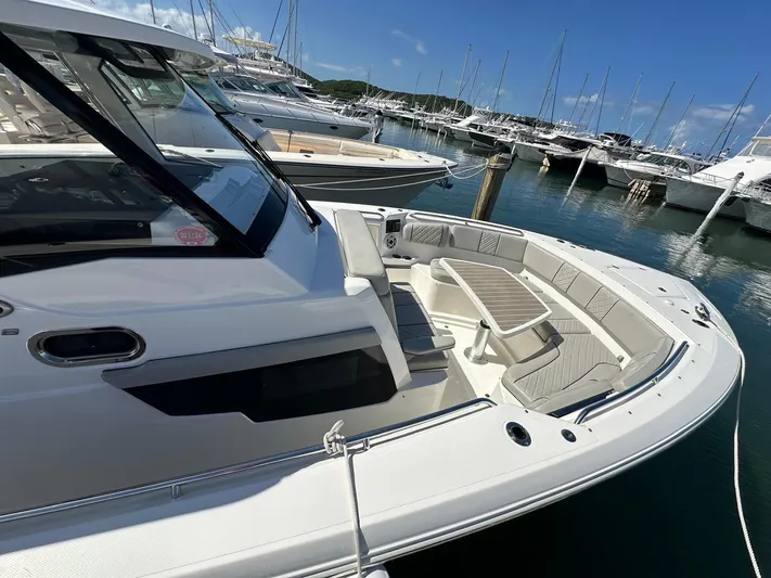  Yacht Photos Pics 2023 Pursuit S 358 Sport boat docked in marina, featuring spacious seating area.