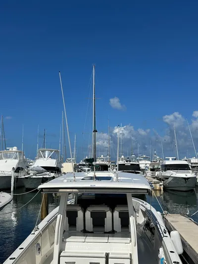  Yacht Photos Pics 2023 Pursuit S 358 Sport boat docked in a marina under clear blue skies.