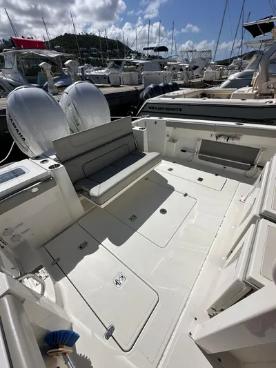  Yacht Photos Pics 2023 Pursuit S 358 Sport boat interior with seating and twin engines in marina.