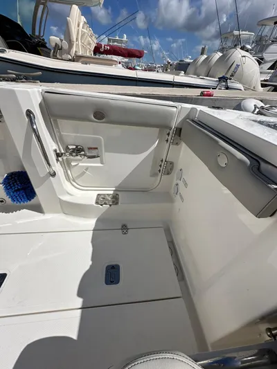  Yacht Photos Pics 2023 Pursuit S 358 Sport boat interior with open hatch and docked vessels.