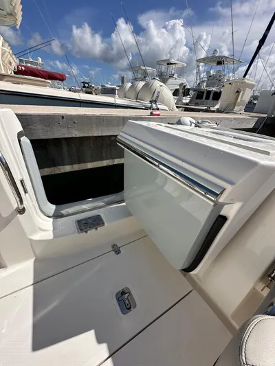  Yacht Photos Pics 2023 Pursuit S 358 Sport boat interior with open hatch, docked under a blue sky.