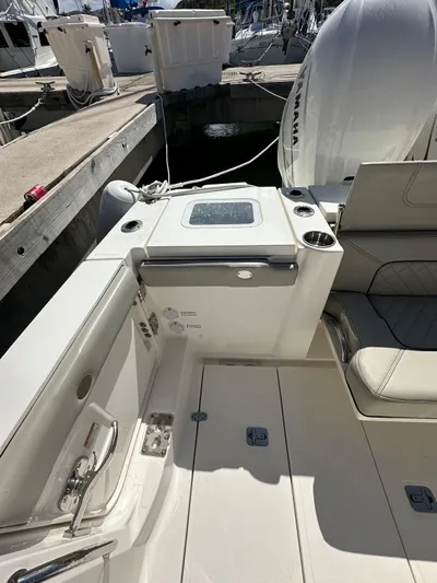  Yacht Photos Pics 2023 Pursuit S 358 Sport boat interior with seating and storage at a marina.