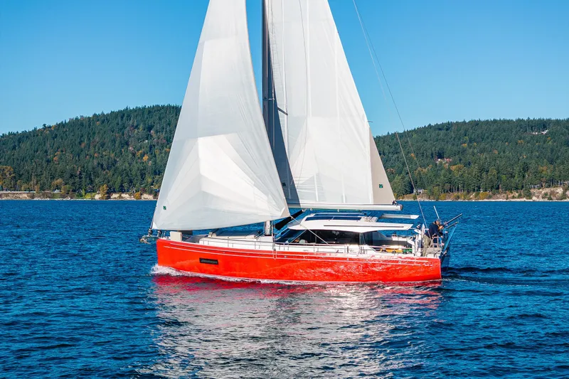 In Stock - W / Warranty Yacht Photos Pics 2024 Moody 41ds sailboat with red hull sailing on a clear blue lake.