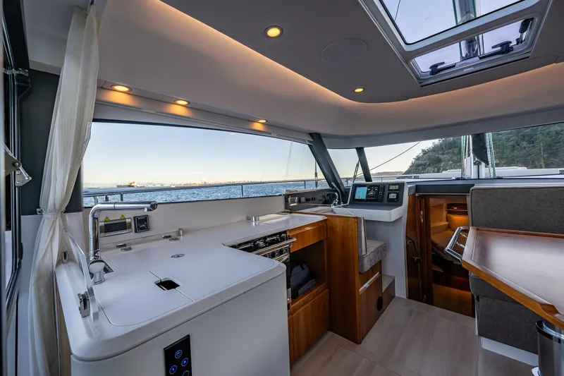 In Stock - W / Warranty Yacht Photos Pics Luxurious interior of 2024 Moody 41ds yacht with modern kitchen and ocean view.