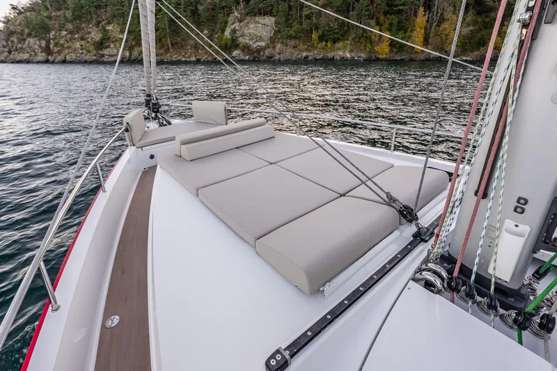 In Stock - W / Warranty Yacht Photos Pics 2024 Moody 41ds sailboat with spacious deck and comfortable seating, cruising near forested shoreline.