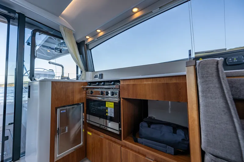 In Stock - W / Warranty Yacht Photos Pics Modern kitchen interior on 2024 Moody 41ds yacht with wood cabinetry and stainless appliances.